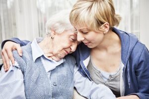 home caregiver consoling sad senior woman