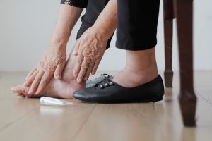 Close of of elderly woman's feet as she grasps one in pain